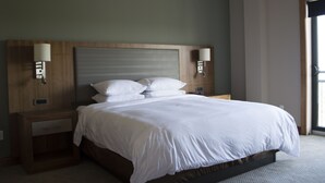 Una cama bien hecha con sábanas blancas en una habitación de hotel.