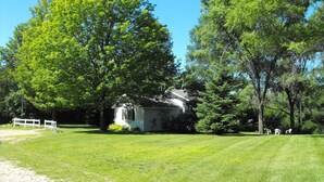 A house surrounded by a well-maintained lawn and large trees.