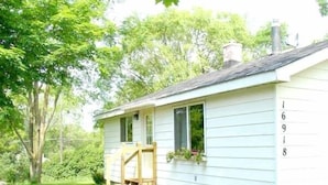 A small, single-story house with a porch and a chimney.