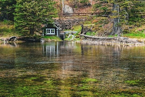 A cabin by a lake surrounded by trees.