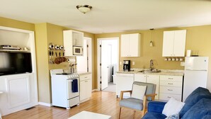 Un espacio habitable compacto con kitchenette, comedor y sofá.