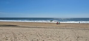 Una playa con huellas, una persona y un vehículo.