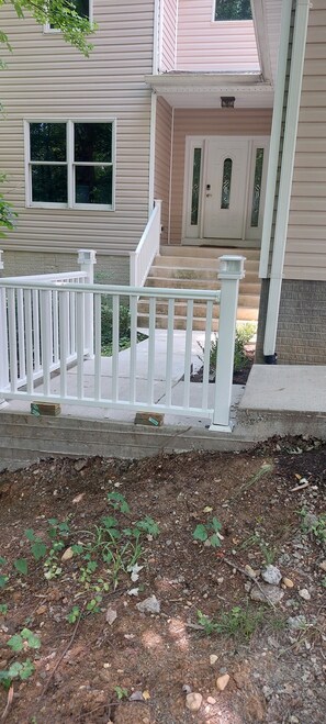 Stroll up to the entrance of this charming two-story residence, featuring a cozy front porch and inviting steps.