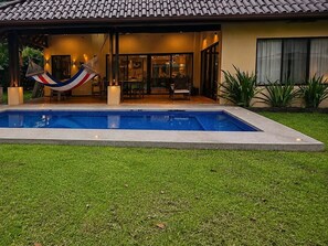 A swimming pool with a hammock, a covered patio, and a house with a tiled roof. - Private, quiet home outside of busy La Fortuna, near hot springs! (La Fortuna)