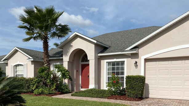 A residential house with a red door, a garage, and a well-maintained lawn. - Last-Minute-Rates  . LET YOUR DREAMS COME TRUE - King Bed, Gas Grill & Game Room (Davenport)