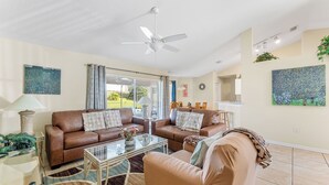 A living room with two brown leather sofas, a glass coffee table, and a beige armchair. - Last-Minute-Rates  . LET YOUR DREAMS COME TRUE - King Bed, Gas Grill & Game Room (Davenport)