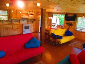 Relax in this cabin-style accommodation with a living area featuring a sofa, dining table, and kitchenette.