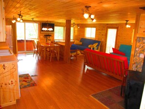 Cozy cabin interior with a dining table for four, sofa, and wooden bench.