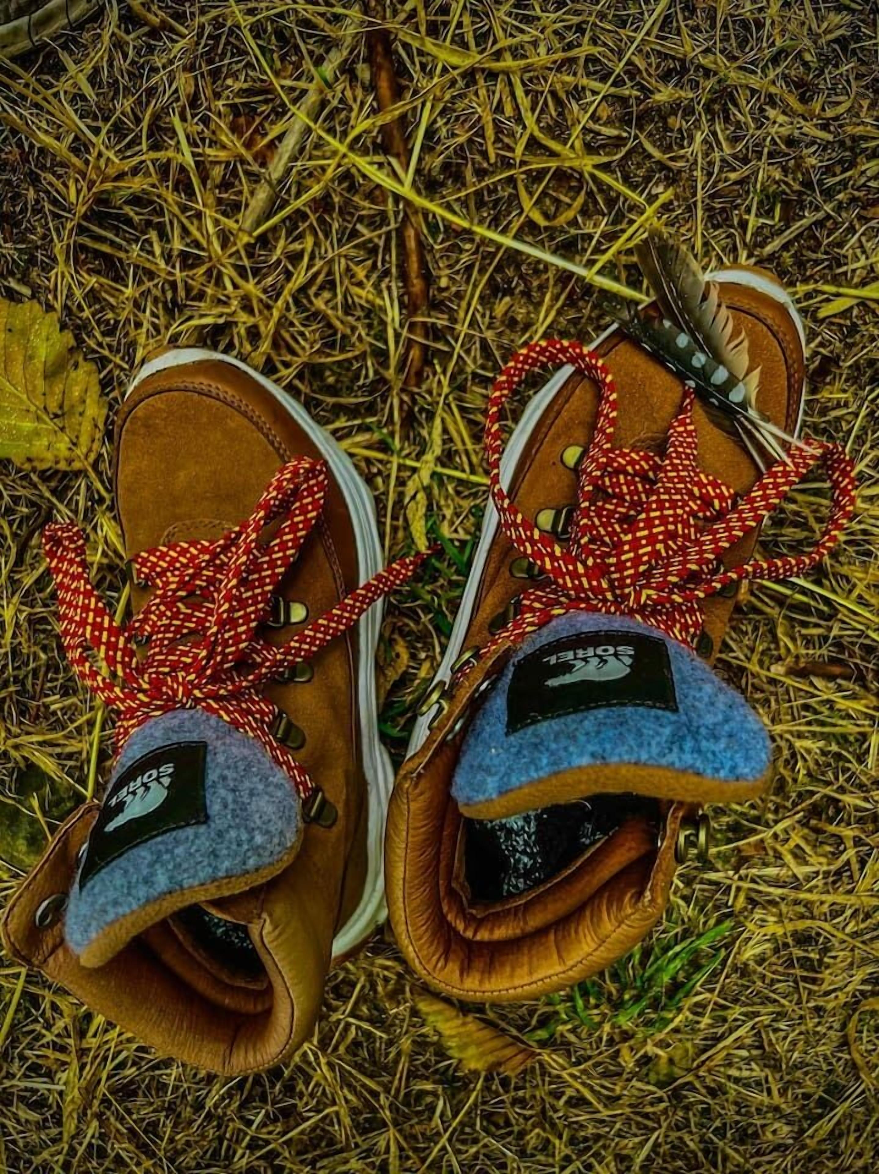 A pair of brown shoes with red and white checkered laces and a blue fleece lining.