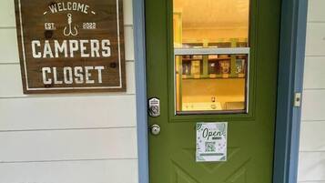 A green door with a sign above it that reads "Welcome Campers Closet."