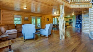 Un intérieur de cabane en bois spacieux, comprenant un espace de vie, un coin repas et une cuisine.