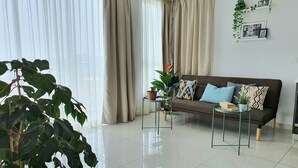 A modern living room with a sofa, a coffee table, and a potted plant. - Prime apartment in Haven Ipoh  (Ipoh)