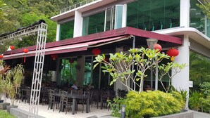 An outdoor dining area with tables and chairs, surrounded by greenery and red lanterns. - Prime apartment in Haven Ipoh  (Ipoh)
