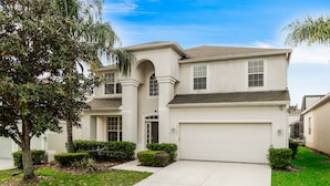 A two-story house with a garage, a driveway, and well-maintained landscaping.