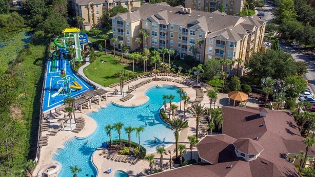 A resort with a large swimming pool, a water park, and multiple residential buildings.
