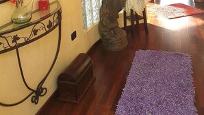 A hallway with a statue, a glass partition, and a table with a vase. - Adeje Tijoco Alto Overseas Real Estate Villa (Palm-Mar)