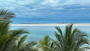 Een privéstrand, ligstoelen aan het strand, parasols, strandlakens