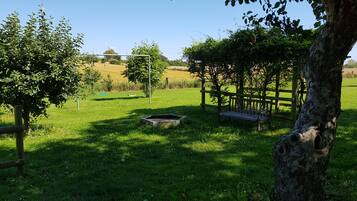 Relax in a serene garden setting with a bench, swing set, and lush greenery.