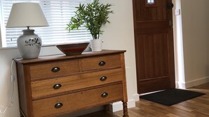A wooden dresser with drawers, a lamp, and a potted plant in front of a window with blinds. - Perfect for walkers, Goodwood, National Trust, Short Stay (Bramshott Chase)