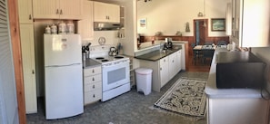 Compact kitchen with essential appliances and storage, featuring a refrigerator, stove, and sink.