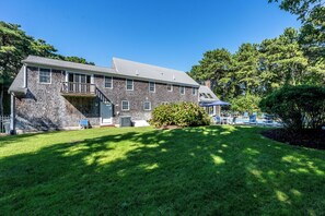 A two-story house with a front porch, a covered patio area, and a well-maintained lawn.