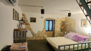 A bedroom with a stone wall, a bed, a window, and a staircase. - Waterfront Dalmatian Stone Villa with Panoramic Adriatic Views, Kastel Novi (Kaštel Novi)