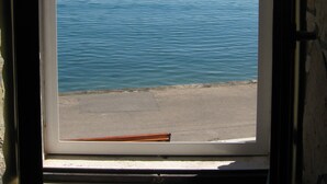 A window with a view of a calm sea and distant hills. - Waterfront Dalmatian Stone Villa with Panoramic Adriatic Views, Kastel Novi (Kaštel Novi)