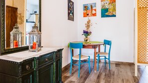 Een eetruimte met een tafel, stoelen en kunstwerken aan de muur.