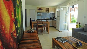 Ein modernes Wohnzimmer mit Couch, Holz-Couchtisch und einem farbenfrohen abstrakten Gemälde an der Wand.
