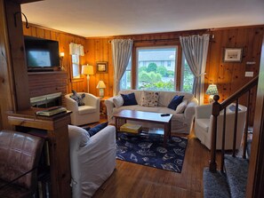 A cozy living room with a fireplace, a sofa, a coffee table, and a TV. - Adorable Cottage, short walk to Beach Weekly and Monthly offering until May 2026 (Narragansett)