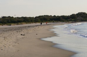A beach with a sandy shore, waves, and a few people walking. - Adorable Cottage, short walk to Beach Weekly and Monthly offering until May 2026 (Narragansett)