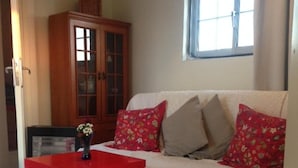 A living room with a white sofa, red table, and a wooden cabinet. - Private 6th floor apt!Double bed and Acropolis view!!In the center of Athens (Athens)
