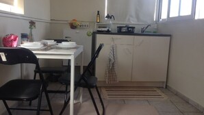 A small kitchen with a dining table, chairs, a refrigerator, and a window. - Private 6th floor apt!Double bed and Acropolis view!!In the center of Athens (Athens)