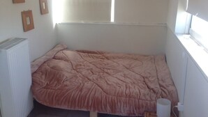A small, single-bed room with a pink bedspread, a radiator, and a window with blinds. - Private 6th floor apt!Double bed and Acropolis view!!In the center of Athens (Athens)