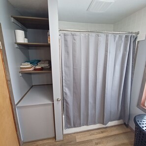 Kombinert dusj/badekar, håndklær og toalettpapir
