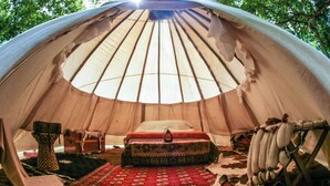 A cozy tent with a bed, a rug, and a hanging bag. - ❤️ THE MAGIC TIPI RETREAT (Park Hills)