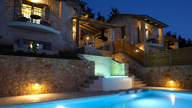 Ein Gebäude aus Stein mit Pool, Treppe und Außenbereich zum Sitzen.