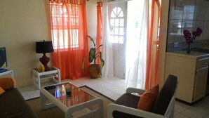 A living room with a sofa, a coffee table, a TV, and a potted plant. - Rodney Bay Beach Home near EVERYTHING (Rodney Bay)