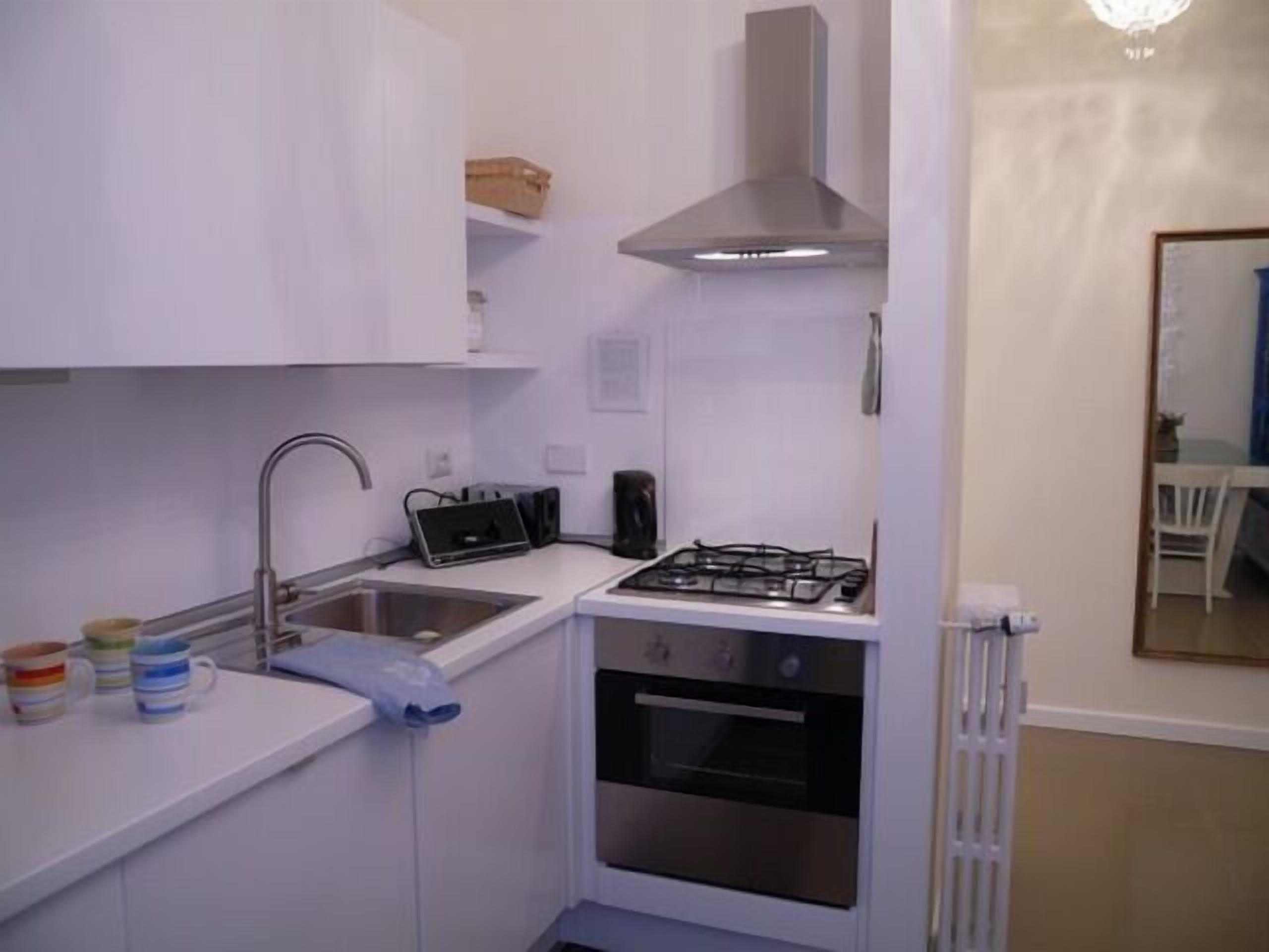 A compact kitchen with a gas stove, oven, and a sink.