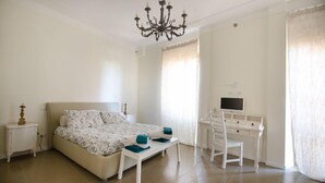 A bedroom with a bed, bedside table, desk, chair, and a TV. - Central 7 pax apartament Near The Colosseum! (rome)