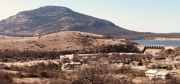 A town with a prominent hill and a dam in the background. - In the Heart of Medicine Park - Surrounded by Stunning Views (Medicine Park)