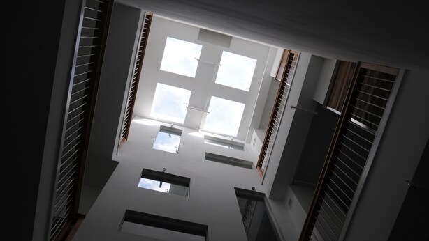 A high-ceilinged interior with skylights and built-in shelving.