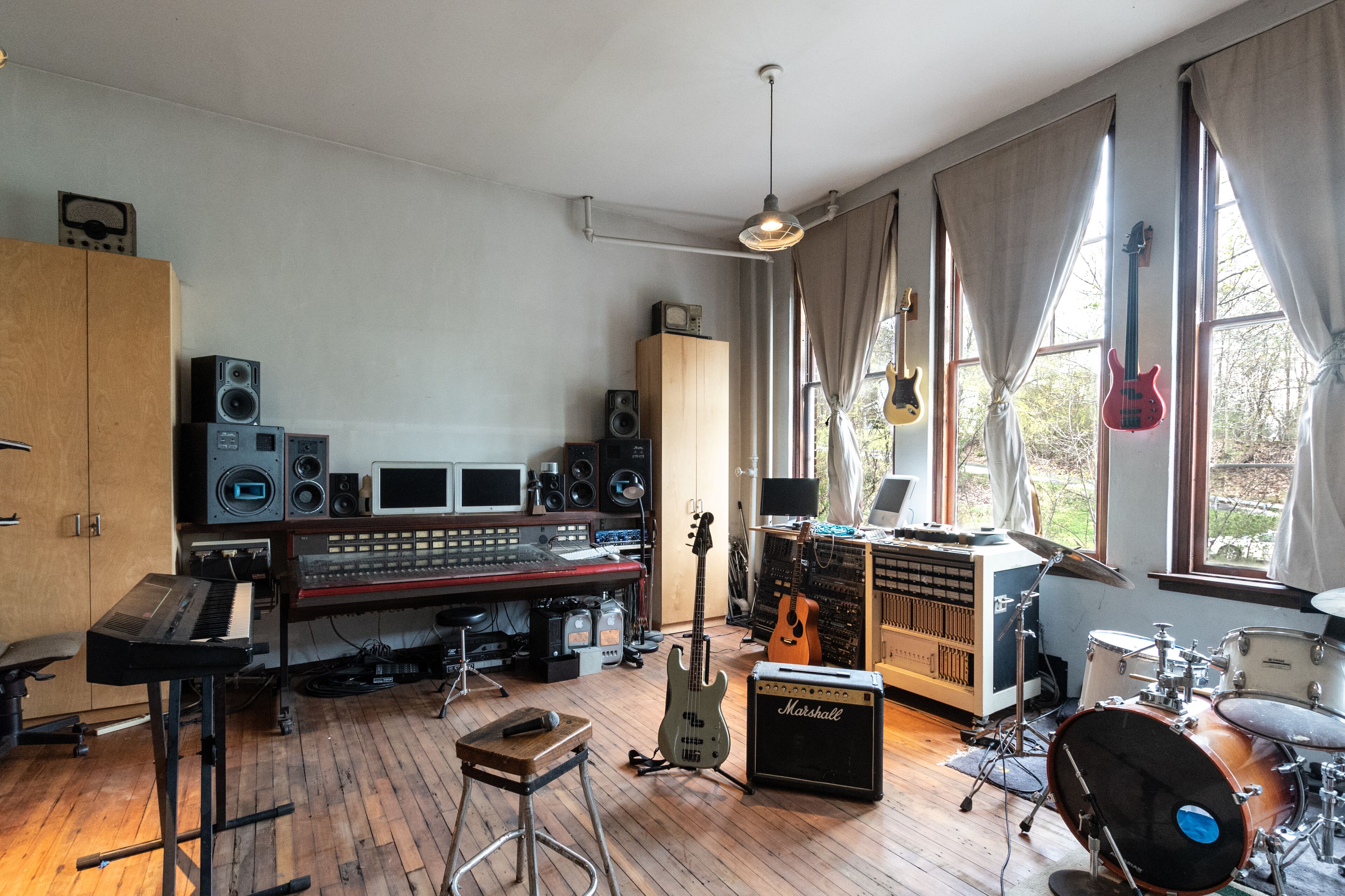 A music studio with various instruments, a mixing console, and recording equipment.