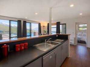 Een moderne keuken met een groot raam, een spoelbak en rode bakken.