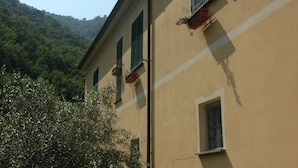 A building with three windows, each with green shutters, and a small window below. - Holiday home - Casa Ruà (Zoagli)