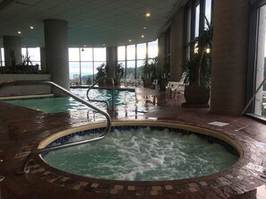 A hot tub area with a view of the outdoors through large windows.