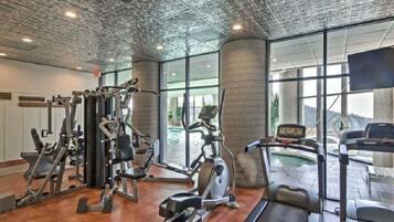 Une salle de sport équipée de machines de cardio, de matériel de musculation et d’un tapis de course.