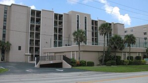 A multi-story building with a flat roof, large windows, and a central entrance with a ramp. - Awesome 6th Story View Of The Ocean, Pool And Beach  (Ponce Inlet)