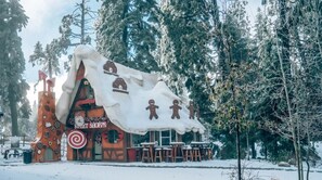 A gingerbread house-themed building with a sign reading "Sweet Shoppe" and outdoor seating. - Bugsy’s Hideout | Intrigue |Romance | Historic (Lake Arrowhead)