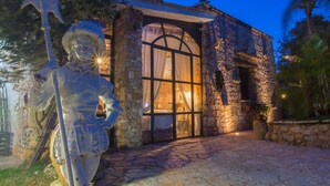 Un edificio de piedra con un gran arco de entrada y una estatua al frente.